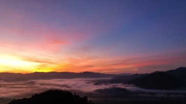 aerial view beautiful sunrise at the horizon of mountain range in Phang Nga Thailand.The mist poured down from the mountains in the morning.beautiful sunrise colorful sky over the mist background.