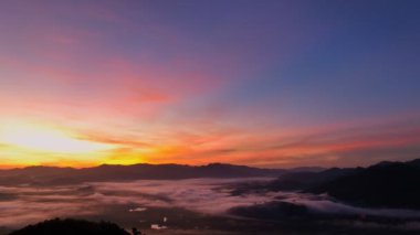 aerial view beautiful sunrise at the horizon of mountain range in Phang Nga Thailand.The mist poured down from the mountains in the morning.beautiful sunrise colorful sky over the mist background.