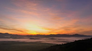 aerial view beautiful sunrise at the horizon of mountain range in Phang Nga Thailand.The mist poured down from the mountains in the morning.beautiful sunrise colorful sky over the mist background.