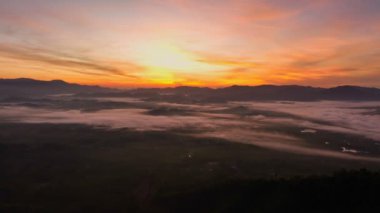 Phang Nga Tayland 'daki dağ sırasının ufkunda güzel bir gün doğumu. Sis sabah dağlardan yağdı. Sisin üzerine güzel bir gün doğumu renkli gökyüzü..