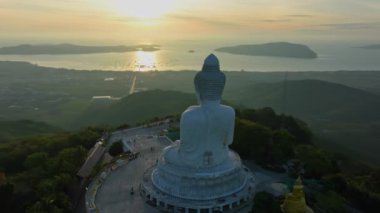 aerial view beautiful sunrise at Phuket big Buddha on the hilltop. Phuket white big Buddha is the famous landmark in Phuket.Aerial panoramic view landscape Phuket big Buddha.