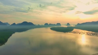 aerial view beautiful sky at twilight above mangrove forest.large canal from mangrove forest connect to Andaman sea.fog flotting above the mangrove forest.4k video colorful sky background.