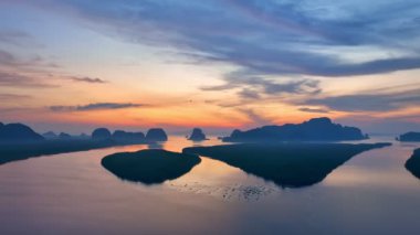 aerial view beautiful sky at twilight above mangrove forest.large canal from mangrove forest connect to Andaman sea.fog flotting above the mangrove forest.4k video colorful sky background.