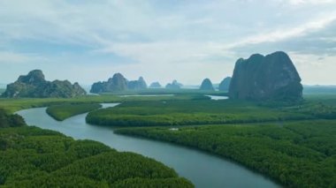 aerial Hyperlapse view above canal in the green field. large canal from mangrove forest connect to Andaman sea.sunet above the group of islands in Phang Nga.4k video colorful sky background.