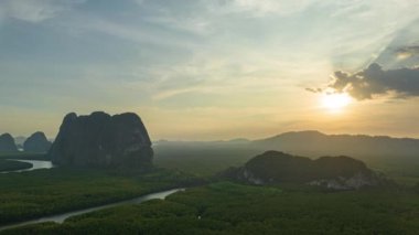 aerial Hyperlapse view above canal in the green field. large canal from mangrove forest connect to Andaman sea.sunet above the group of islands in Phang Nga.4k video colorful sky background.