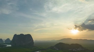 aerial Hyperlapse view above canal in the green field. large canal from mangrove forest connect to Andaman sea.sunet above the group of islands in Phang Nga.4k video colorful sky background.