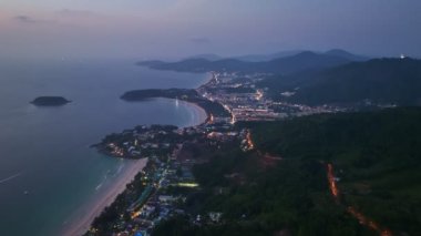 .aerial view The lights twinkled along the three beaches at night..Kata Noi beach, Kata beach and Karon beach..Bright colors along the beach area at night..