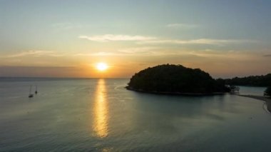 .aerial hyper lapse view beautiful sunset above Kala island at Layan beach Phuket..colorful sky of sunset at horizon.Phuket beach sea Amazing beach, .Beautiful beach Phuket Thailand,t..