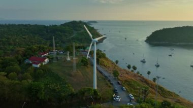 aerial view Wind turbine blades spinning on top of a mountainWind power generates electricity. Clean energy from nature.Landmark Windmill Viewpoint close to Promthep cape.sea  and sky background.