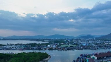 Phuket 'in en büyük balıkçılık limanı ve Phuket tersanesinde geniş bir kanal görünüyor. Phuket balıkçılık limanının üzerinde gün batımında güzel bir bulut. balıkçı tekneleri.