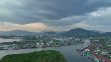 Phuket 'in en büyük balıkçılık limanı ve Phuket tersanesinde geniş bir kanal görünüyor. Phuket balıkçılık limanının üzerinde gün batımında güzel bir bulut. balıkçı tekneleri.