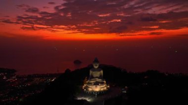 Phuket Büyük Buda 'da alacakaranlıkta inanılmaz bir kızıl gökyüzü. Kumsal boyunca ve Phuket Adası etrafındaki çeşitli kasabalarda parlayan ışıklar. yaratıcı seyahat konsepti. çarpıcı kırmızı gökyüzü arkaplanı.
