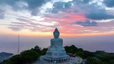  Phuket Büyük Buda 'nın güzel günbatımında gökyüzü yanılıyor güneş bulutların arasından parlıyor okyanus yüzeyine çarpıyor. Heykelin güzelliği büyüleyici doğayla mükemmel bir şekilde örtüşüyor. Bulut manzarası..