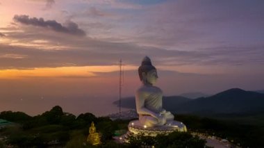 Phuket Büyük Buda 'nın güzel günbatımında gökyüzü yanılıyor güneş bulutların arasından parlıyor okyanus yüzeyine çarpıyor. Heykelin güzelliği büyüleyici doğayla mükemmel bir şekilde örtüşüyor. Bulut manzarası..