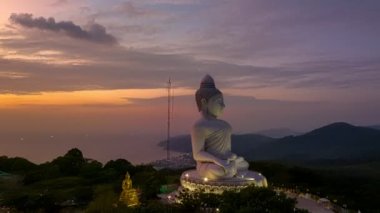  Phuket Büyük Buda 'nın güzel günbatımında gökyüzü yanılıyor güneş bulutların arasından parlıyor okyanus yüzeyine çarpıyor. Heykelin güzelliği büyüleyici doğayla mükemmel bir şekilde örtüşüyor. Bulut manzarası..