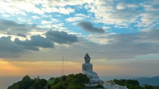 美しい夕日の中にあるプーケットの大きな仏像は 太陽が海の表面に雲の影響を通して輝きます — ストック動画