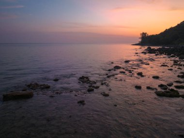 Güneşin rengarenk gökyüzünde batışı okyanus yüzeyine çarpıyor.