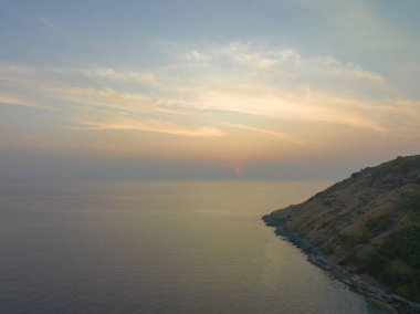 Güneşin rengarenk gökyüzünde batışı okyanus yüzeyine çarpıyor.