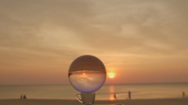 Sahildeki kristal kürenin üzerindeki muhteşem gökyüzü. Islak kumsaldaki kristal kürenin üzerindeki gökyüzünün güzel yansıması.