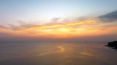 ..Hava hiperhız görüntüsü denizde baş döndürücü bir gün batımı. Gökyüzünün rengini değiştiren romantik günbatımı sahnesi. Gün batımında güzel kırmızı bulut. Soyut doğa arkaplanı..