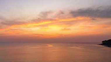 ..Hava hiperhız görüntüsü denizde baş döndürücü bir gün batımı. Gökyüzünün rengini değiştiren romantik günbatımı sahnesi. Gün batımında güzel kırmızı bulut. Soyut doğa arkaplanı..