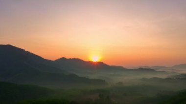 Dağ sırtı üzerinde hava manzarası nefes kesici bir gün doğumu. Karanlık vadide sisli, renkli ışık yalağı manzarası. Gökyüzü dokusu, inanılmaz soyut doğa arkaplanı.