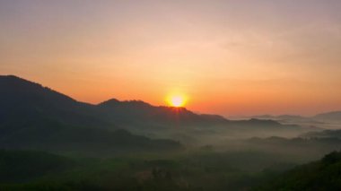 Dağ sırtı üzerinde hava manzarası nefes kesici bir gün doğumu. Karanlık vadide sisli, renkli ışık yalağı manzarası. Gökyüzü dokusu, inanılmaz soyut doğa arkaplanı.