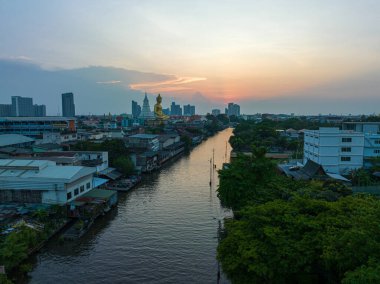 Büyük Buda Wat Paknam Phasi Charoen gün batımında. Büyük Buda 'nın önündeki bir kanalda gün batımının güzel yansıması. Alacakaranlık arkaplanındaki gökyüzü. Tayland 'ın en ünlü simgeleri...