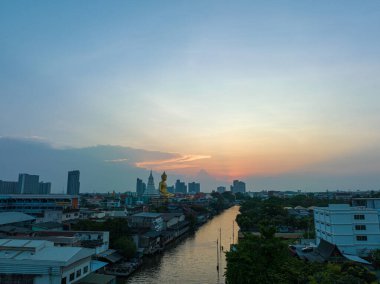 Büyük Buda Wat Paknam Phasi Charoen gün batımında. Büyük Buda 'nın önündeki bir kanalda gün batımının güzel yansıması. Alacakaranlık arkaplanındaki gökyüzü. Tayland 'ın en ünlü simgeleri...