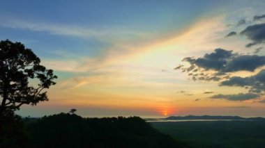Hava manzarası adanın kenarında gün batımında inanılmaz sarı gökyüzü... Phang Nga Tayland 'da güzel sarı günbatımı... 4k renkli gökyüzü arkaplanı.