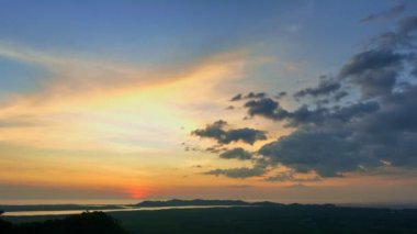 Hava manzarası adanın kenarında gün batımında inanılmaz sarı gökyüzü... Phang Nga Tayland 'da güzel sarı günbatımı... 4k renkli gökyüzü arkaplanı.