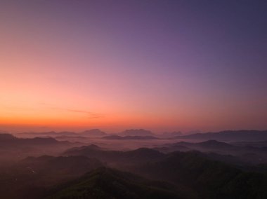 Hava manzarası Şafak vakti vadideki sisli denizin üzerinde gökyüzünde inanılmaz renkler.