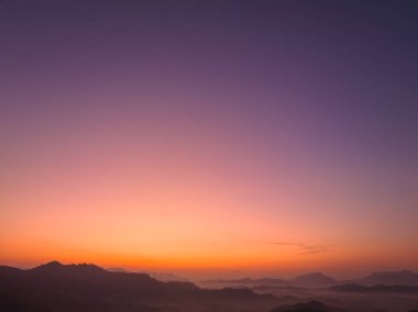 Hava manzarası Şafak vakti vadideki sisli denizin üzerinde gökyüzünde inanılmaz renkler.
