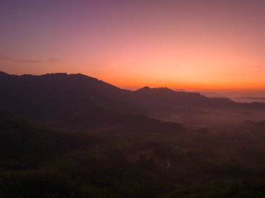 Hava manzarası Şafak vakti vadideki sisli denizin üzerinde gökyüzünde inanılmaz renkler.
