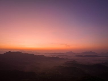 Hava manzarası Şafak vakti vadideki sisli denizin üzerinde gökyüzünde inanılmaz renkler.