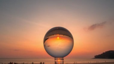 Plaj videosu 4K 'nin yanında kristal küre içinde gün batımını hızlandırıyor. Doğa Video Yüksek kaliteli görüntüler gece gündüz doğa ve seyahat konsepti eşsiz ve yaratıcı seyahat doğa fikri..