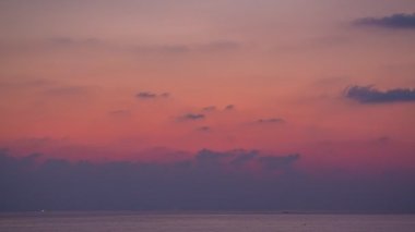 Güneş denizin üzerinde batarken gökyüzü sarıdan kırmızıya döner gün batımı doğanın inanılmaz ışığı bulutlu gökyüzü. - Büyük güneş ve kırmızı ışıklı gökyüzü arkaplanı. 4k çözünürlüğü