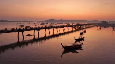 Hava manzaralı güzel güneş Chalong marinasının üzerinde parlıyor. Görkemli gündoğumu manzarası doğanın inanılmaz ışığı dağ sırasının üstündeki gökyüzünü bulutlandırıyor. Renkli gün doğumu. Chalong körfezindeki tekneler.
