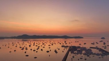Hava manzaralı güzel güneş Chalong marinasının üzerinde parlıyor. Görkemli gündoğumu manzarası doğanın inanılmaz ışığı dağ sırasının üstündeki gökyüzünü bulutlandırıyor. Renkli gün doğumu. Chalong körfezindeki tekneler.