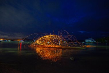 kıvılcım yangın girdap çelik yün uzun pozlama hızı hareket soyut dan gündoğumu, denizde yansıması.