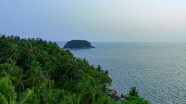 Kayaların ve tepelerdeki yeşil ormanın yanında turkuaz deniz manzarası. Adayı çevreleyen kayalar. Dalgalar Phuket Adası 'ndaki kayalara çarptı. kayaların doku arkaplanı