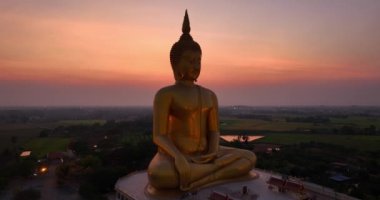.Ay, dünyanın en büyük altın Buda 'sının kafasının üstündeydi. Alacakaranlıkta. Wat Muang Ang Thong Tayland 'da popüler ve ünlü bir mekan olan Altın Gece Atmosferi.