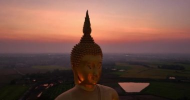 .Ay, dünyanın en büyük altın Buda 'sının kafasının üstündeydi. Alacakaranlıkta. Wat Muang Ang Thong Tayland 'da popüler ve ünlü bir mekan olan Altın Gece Atmosferi.