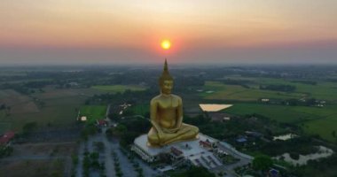 .Ay, dünyanın en büyük altın Buda 'sının kafasının üstündeydi. Alacakaranlıkta. Wat Muang Ang Thong Tayland 'da popüler ve ünlü bir mekan olan Altın Gece Atmosferi.