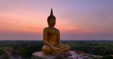 .Ay, dünyanın en büyük altın Buda 'sının kafasının üstündeydi. Alacakaranlıkta. Wat Muang Ang Thong Tayland 'da popüler ve ünlü bir mekan olan Altın Gece Atmosferi.