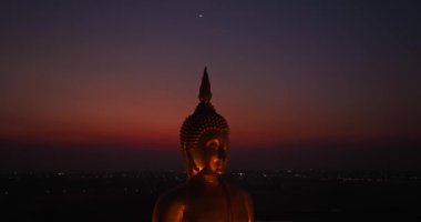 .Ay, dünyanın en büyük altın Buda 'sının kafasının üstündeydi. Alacakaranlıkta. Wat Muang Ang Thong Tayland 'da popüler ve ünlü bir mekan olan Altın Gece Atmosferi.