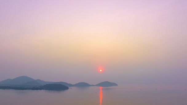空の色を背景にカラフルなロマンチックな空の日の出のシーン 海の背景に島の上の太陽の反射 — ストック動画