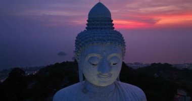 Phuket Büyük Buda 'nın başının arkasındaki alacakaranlıkta mor gökyüzünde inanılmaz renkli bir ışık. Phuket Büyük Buda Phuket4k Video' da seyahat ve dini fikirler için önemli ve ünlü simgelerdir..