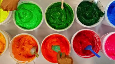 Boyayı kepçele ve birlikte karıştır. Kumaşta baskı yapmak için mürekkep ya da boya çeşitli tipler var. Gömlek fabrikasında kıyafet baskısı için çeşitli renkler. Üst görünüm renkli arkaplan.