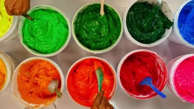 Boyayı kepçele ve birlikte karıştır. Kumaşta baskı yapmak için mürekkep ya da boya çeşitli tipler var. Gömlek fabrikasında kıyafet baskısı için çeşitli renkler. Üst görünüm renkli arkaplan.